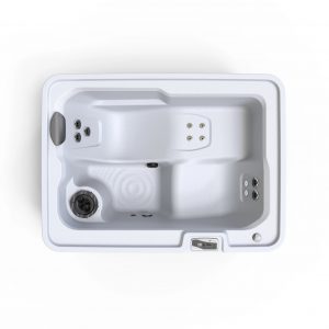 Top-down view of a white rectangular spa/hot tub with built-in seating, multiple jet outlets, and a control panel on the rim