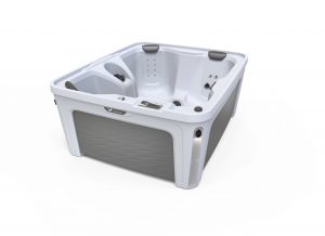 White acrylic hot tub with built-in seating, multiple jets, and a digital control panel visible on the rim.