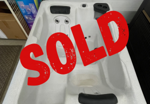 Showroom white hot tub interior with jets, covered by a large red SOLD stamp indicating it’s sold.