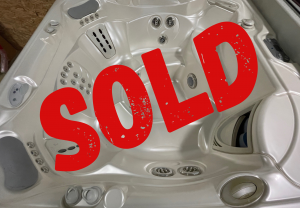 sold refurbs 39 | Young's Hot Tub Sales and Service Center White hot tub interior with multiple jets and seating, overlaid by a large red 'SOLD' stamp indicating it’s sold.