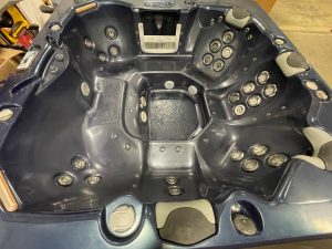 r397 5 | Young's Hot Tub Sales and Service Center Dark gray hot tub interior with numerous round jet nozzles and built-in headrests.