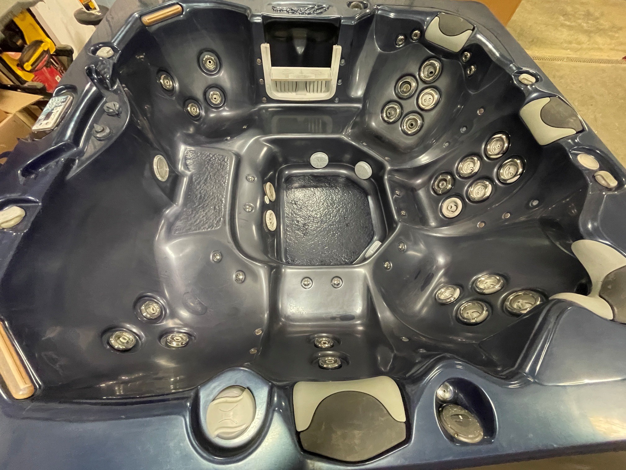 r397 5 | Young's Hot Tub Sales and Service Center Dark gray hot tub interior with numerous round jet nozzles and built-in headrests.