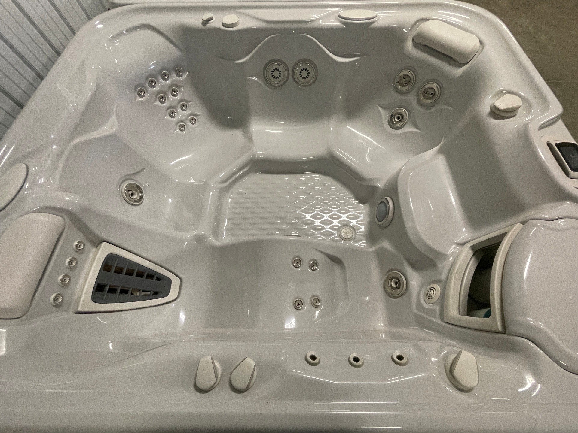 r408 3 | Young's Hot Tub Sales and Service Center Top-down view of a white hot tub with multiple massage jets and built-in seats, showing a textured floor and control panel on the rim
