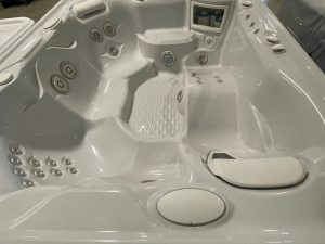 r408 4 | Young's Hot Tub Sales and Service Center Indoor white Jacuzzi/hot tub interior with multiple water jets and seating for several people, control panel visible on the rim.