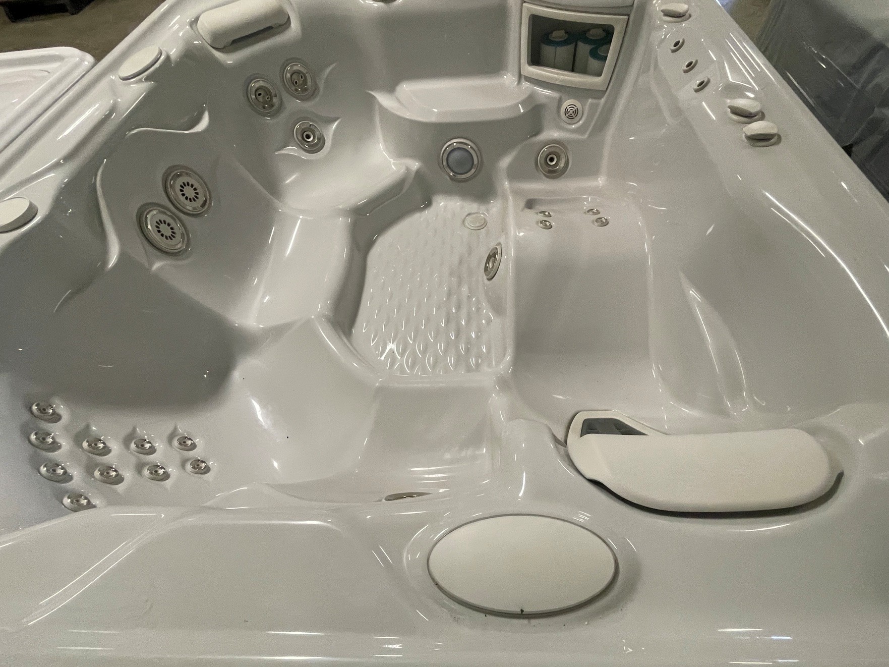 r408 4 | Young's Hot Tub Sales and Service Center Indoor white Jacuzzi/hot tub interior with multiple water jets and seating for several people, control panel visible on the rim.