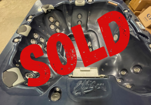 sold refurbs 43 | Young's Hot Tub Sales and Service Center Dark gray hot tub with multiple jet seats and built-in controls, partially covered by a large red SOLD stamp