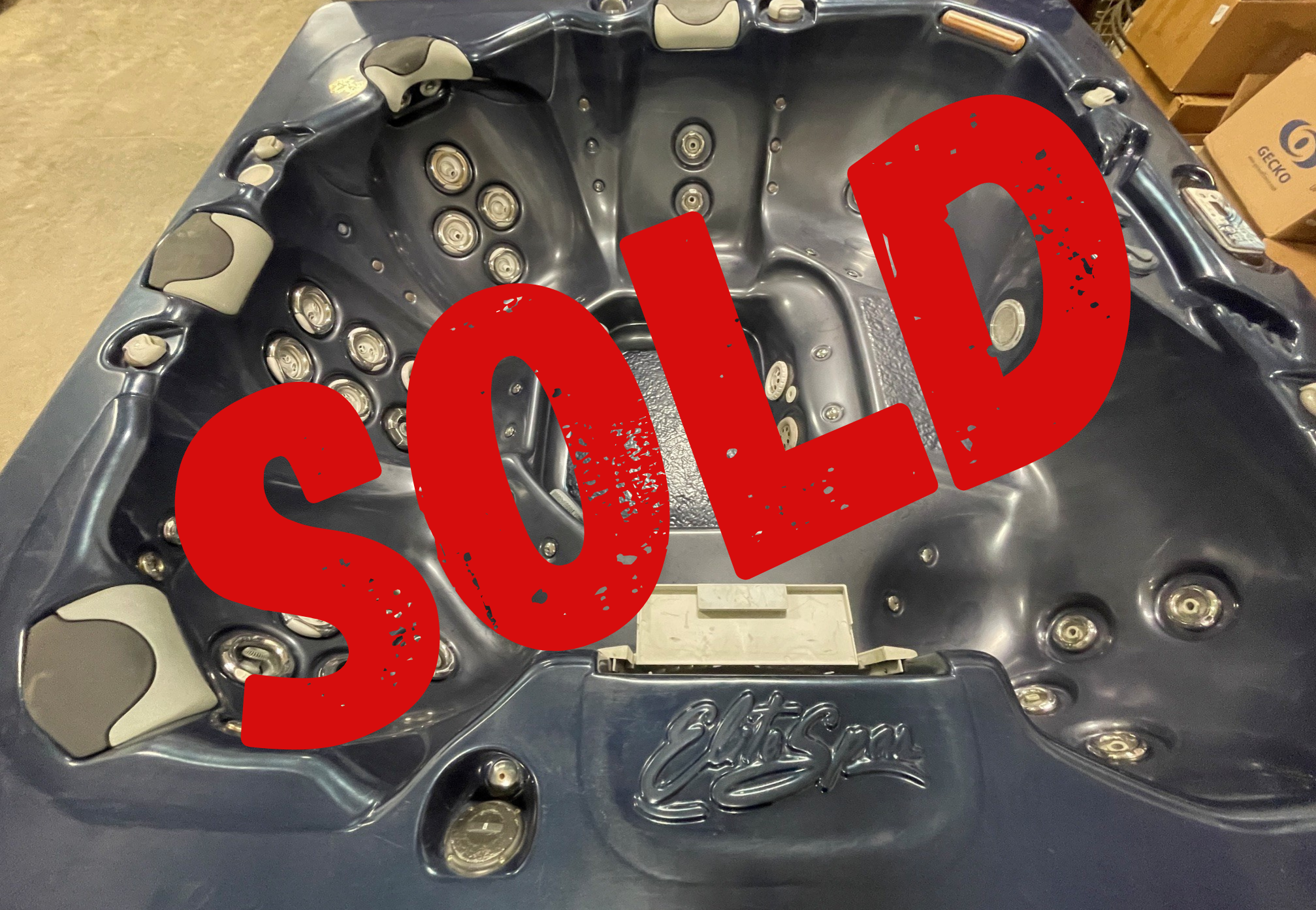 sold refurbs 43 | Young's Hot Tub Sales and Service Center Dark gray hot tub with multiple jet seats and built-in controls, partially covered by a large red SOLD stamp