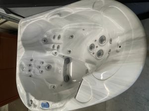 White spa/hot tub interior with numerous jet nozzles and built-in seating, viewed from above/side angle.