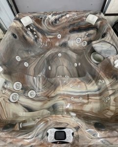 r441 3 | Young's Hot Tub Sales and Service Center Marble-patterned, multi-seat hot tub with numerous jets and a built-in digital control panel at the bottom center.