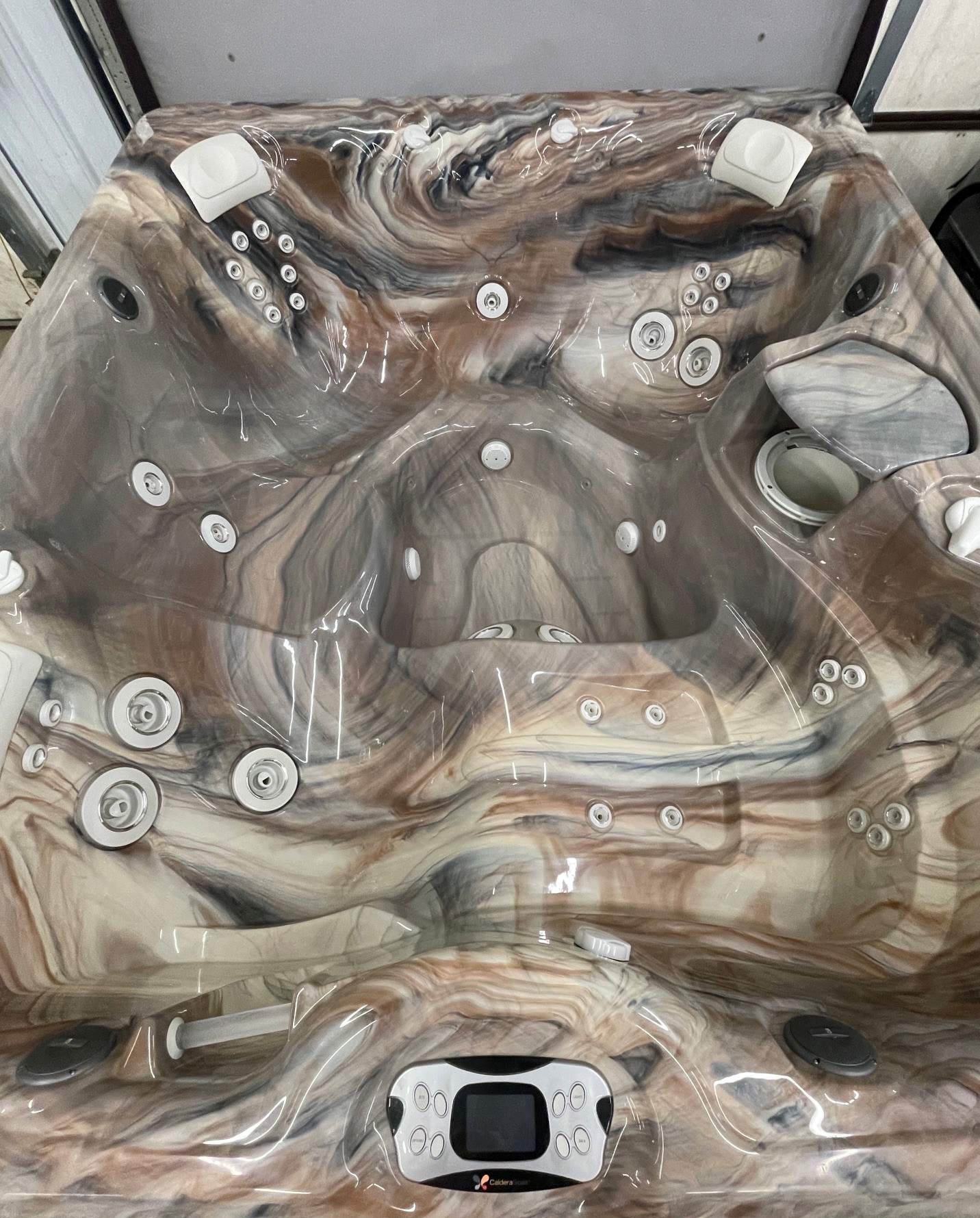 r441 3 | Young's Hot Tub Sales and Service Center Marble-patterned, multi-seat hot tub with numerous jets and a built-in digital control panel at the bottom center.